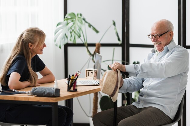 smiley-senior-man-nursing-home-with-nurse_23-2148740001