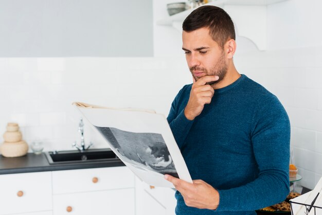 young-adult-is-reading-newspaper-kitchen_23-2148306631